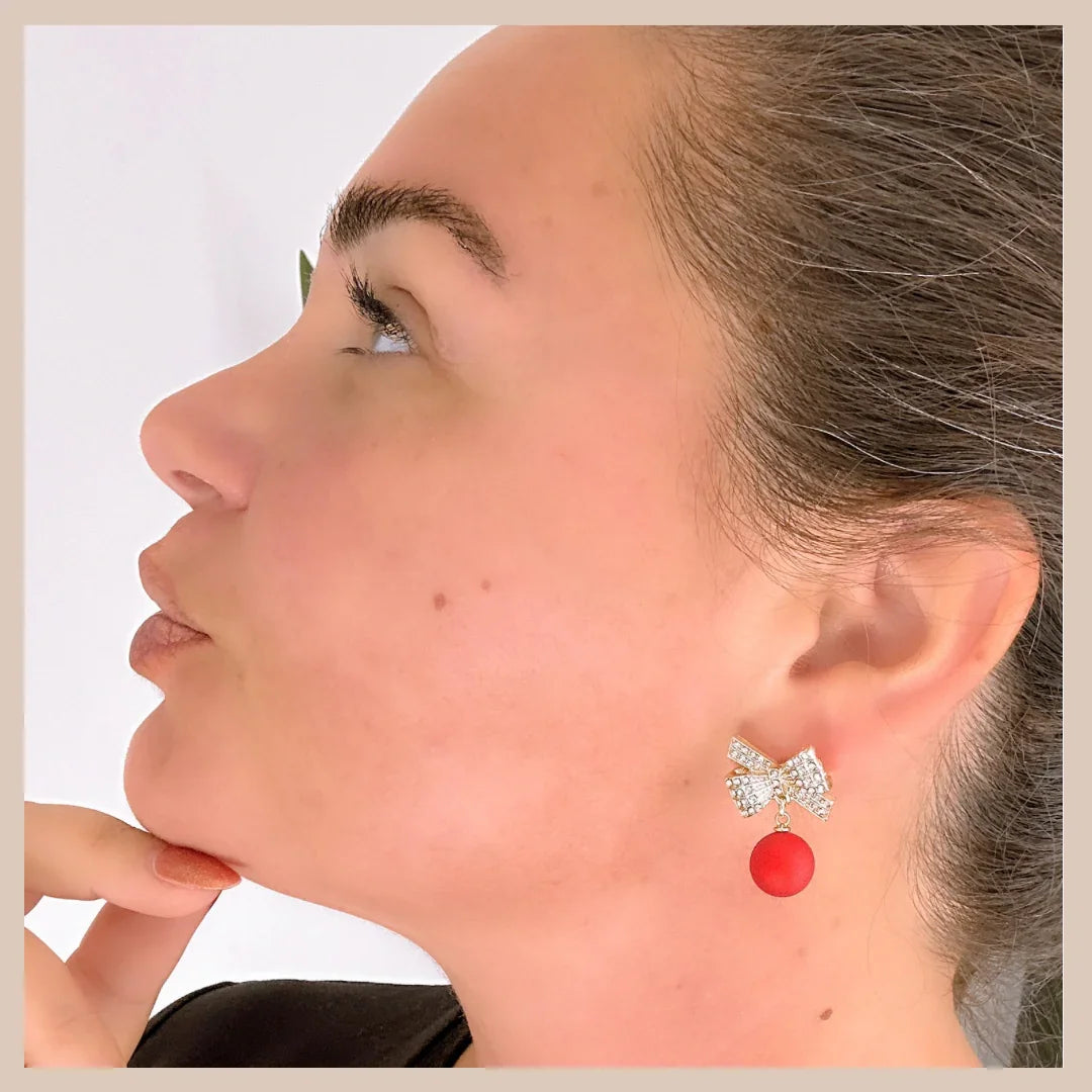 Classy alternative to novelty Christmas earrings – gold bow with red drop